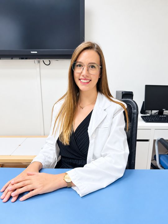 Professional d'ABC asseguda a la taula d'una sala de consulta