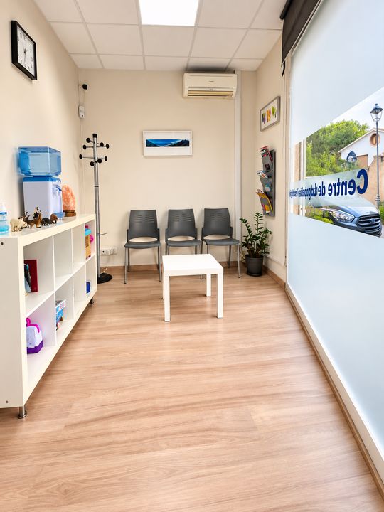 Sala d'espera del centre ABC amb cadires, prestatgeria de jocs i finestral