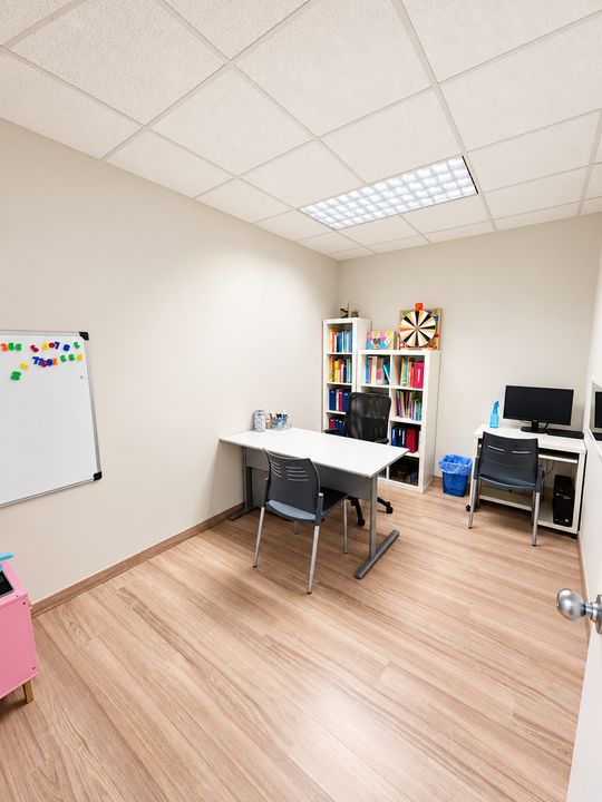 Sala de consulta amb taula de treball, pissarra magnètica i prestatgeria